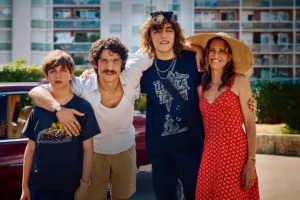 da esquerda para a direita - uma criança, um homem adulto, um adolescente e uma mulher adulta pousam para a fotografia