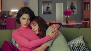 duas mulheres sentadas no sofá, abraçadas, com um ar triste