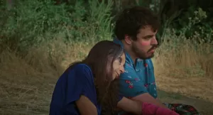 uma mulher encostada ao ombro de um homem