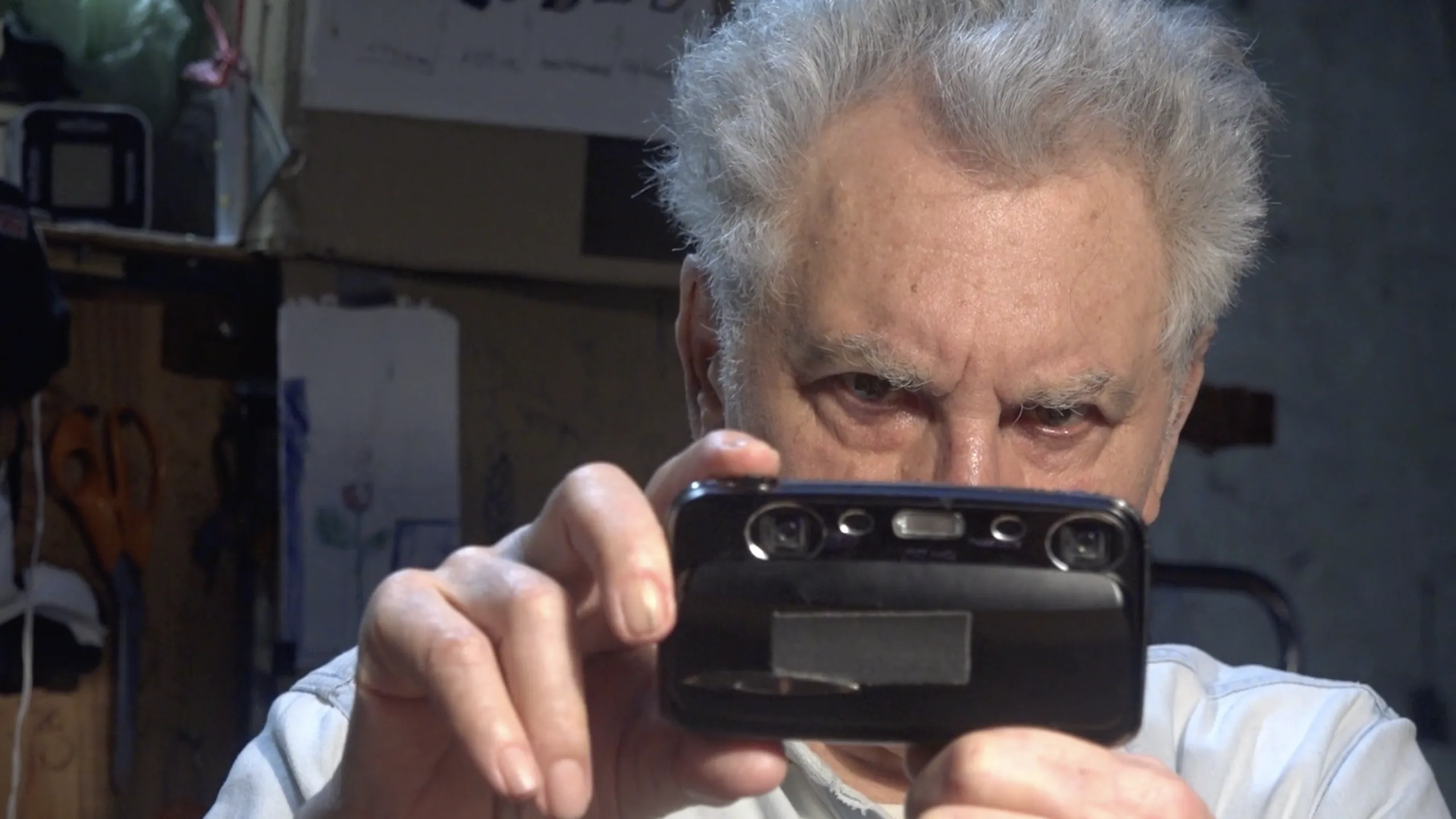 Ken Jacobs com uma pequena câmara a apontar para si