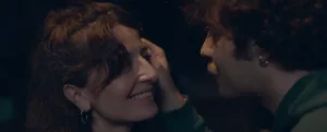 um homem toca na cara de uma mulher e ela sorri