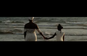 uma mulher e uma criança de mãos dados a olhar para o mar