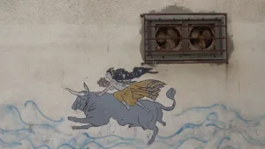 desenho numa fachada com ondas, e uma mulher em cima de um touro