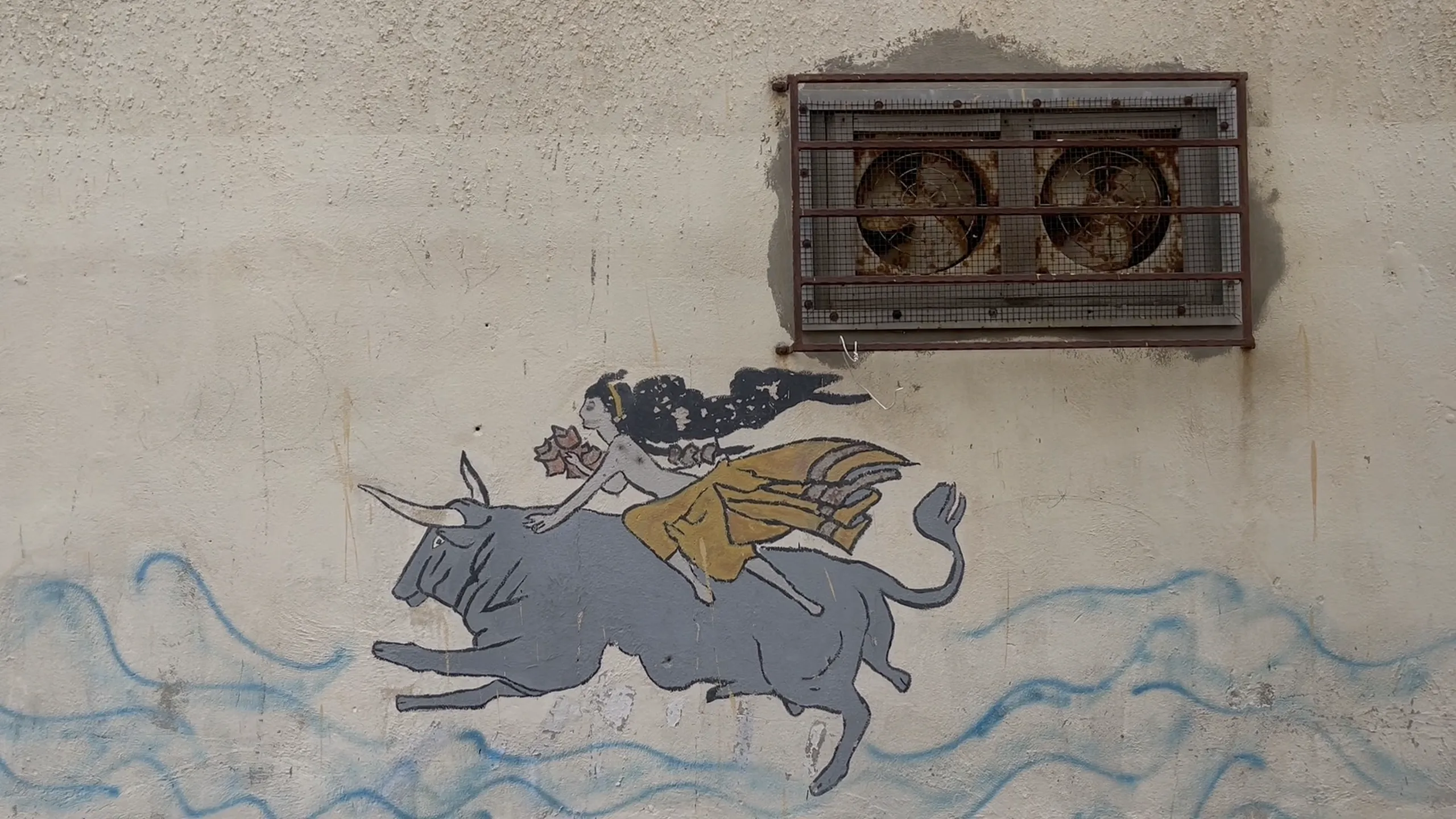 desenho numa fachada com ondas, e uma mulher em cima de um touro