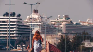mulher a andar e vários navios ao fundo